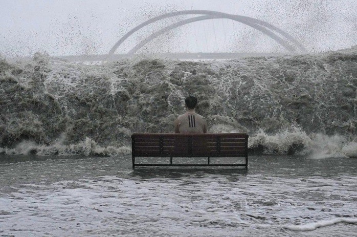 Người đàn ông ngồi trên ghế ở lối đi bộ khi bão Ragasa áp sát Hồng Kông, Trung Quốc, sáng 24-9. Ảnh: Elson Li