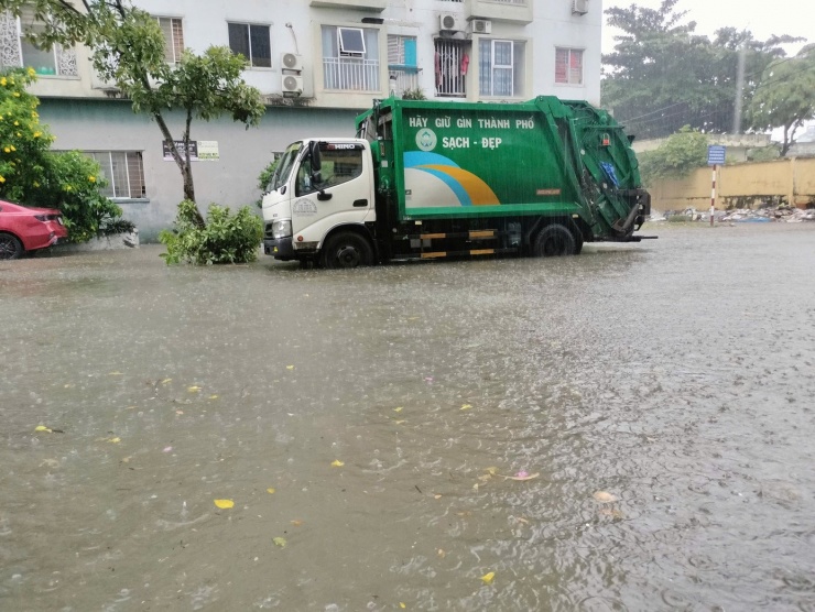 Nước ngập sâu gần nửa bánh xe trên đường Bùi Dương Lịch đoạn gần chợ Nại Hiên Đông.