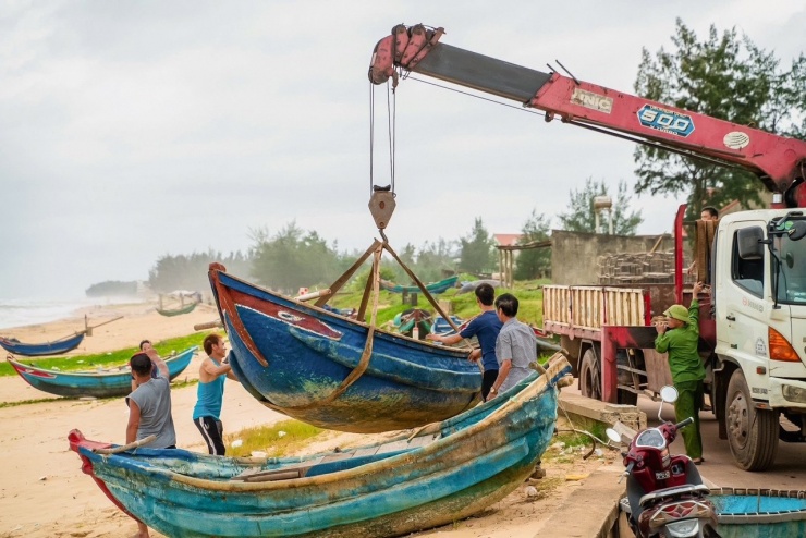 Ở phía bờ biển, những chiếc bơ nan được người dân thuê xe cẩu thuyền lên đưa sâu vào trong bờ nhằm tránh sóng cuốn mất.