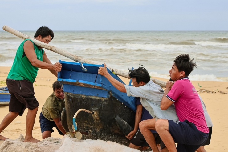 Những gia đình không có điều kiện thuê xe cẩu thì dùng sức người để đưa bơ nan vào bờ.