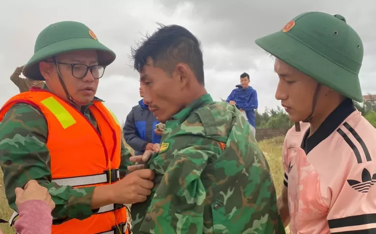 Trung tá Nguyễn Văn Anh, Chính trị viên Đồn Biên phòng cửa khẩu cảng Cửa Việt (bên phải) thăm hỏi thuyền viên tự bơi vào bờ.