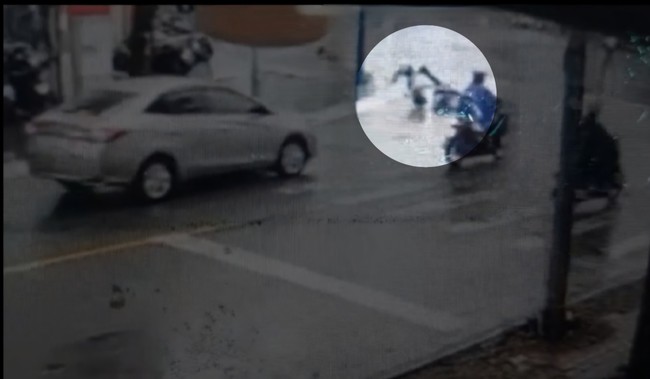 Người đi xe máy té ngã dưới mưa ngay trước chiếc ô tô đi ngược chiều