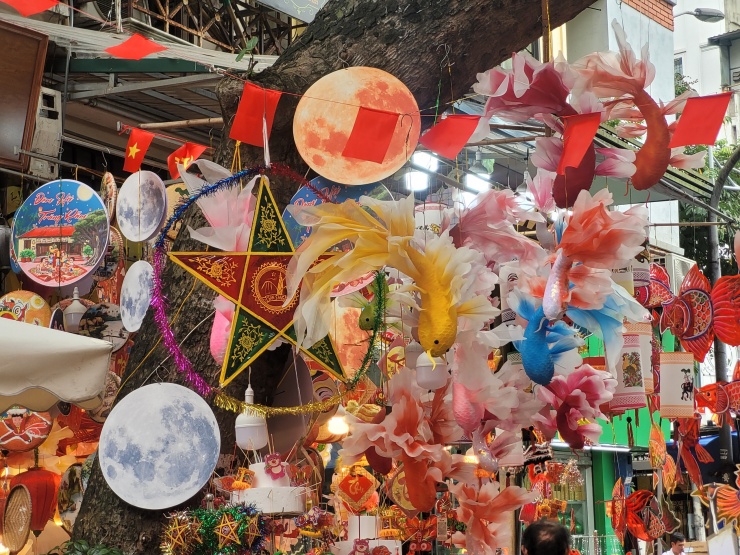 Cận cảnh các sản phẩm "cá chép trông trăng" đang gây sốt năm nay với thiết kế cầu kỳ, phần thân cá uốn lượn mềm mại, đôi mắt tròn hướng về phía vầng trăng tròn treo trên giá đỡ.