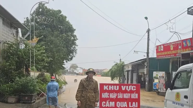 Công an xã Hương Sơn cảnh báo và cấm người dân qua lại khu vực đường ngập sâu.