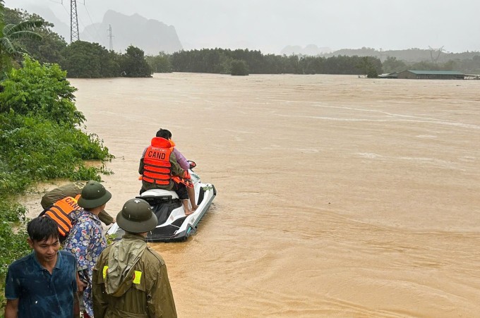 Cảnh sát dùng cano giải cứu 13 người kẹt trong trang trại ở xã Ngọc Lặc. Ảnh: Lam Sơn