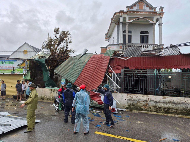 Mái tôn vắt vẻo bên tường rào, lực lượng chức năng quyết định tháo xuống để đảm bảo an toàn.