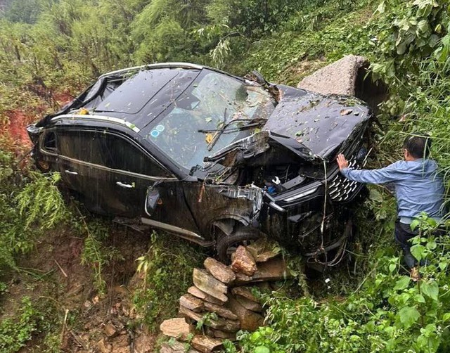 Chiếc xe ô tô con hư hỏng nặng sau khi rơi xuống vực. Ảnh: NDCC