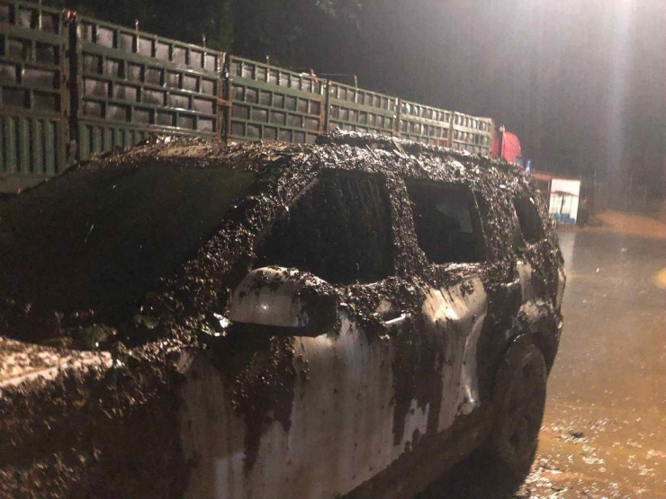 Xe ô tô chở 2 người nước ngoài bị hư hỏng, vỡ kính, bùn đất tràn vào trong xe. Ảnh: BSP