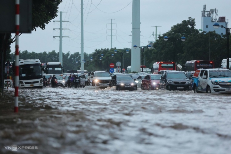 Người Hà Nội chèo thuyền, dắt xe đi làm trong mưa lớn - 1