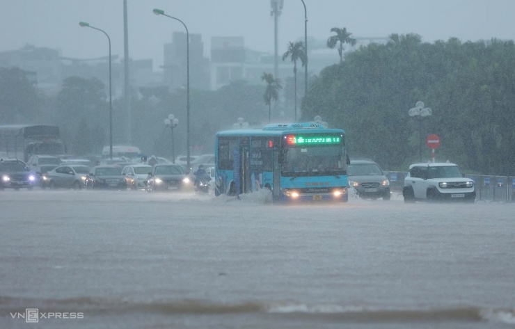 Người Hà Nội chèo thuyền, dắt xe đi làm trong mưa lớn - 4