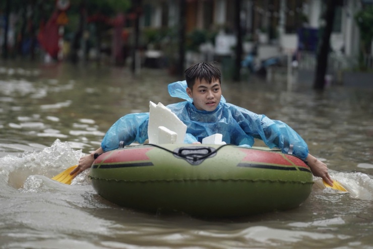 Người Hà Nội chèo thuyền, dắt xe đi làm trong mưa lớn - 6
