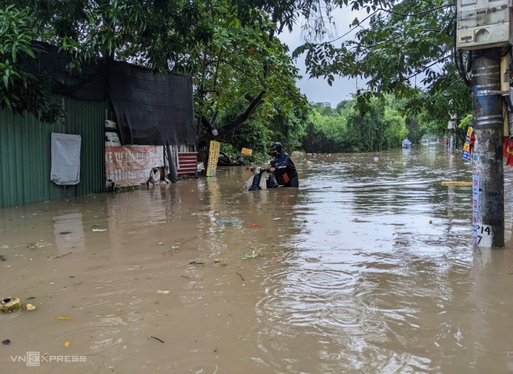 Người Hà Nội chèo thuyền, dắt xe đi làm trong mưa lớn - 5