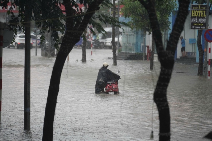 Người Hà Nội chèo thuyền, dắt xe đi làm trong mưa lớn - 8
