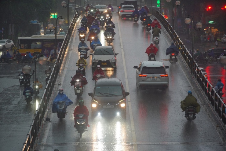 Các phương tiện bật đèn pha di chuyển trên cầu vượt Thái Hà.