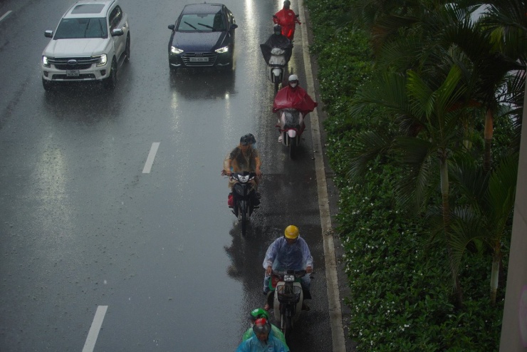 Dòng phương tiện di chuyển sát dải phân cách, dưới đường cao tốc trên cao để "né" mưa.