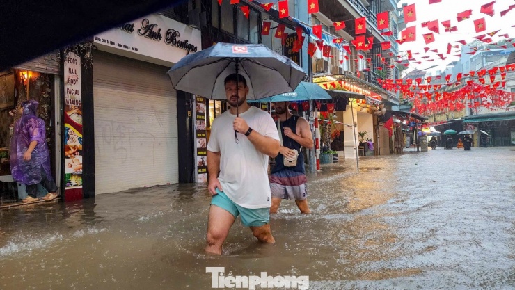 Nhiều du khách nước ngoài dạo 'Phố Tây'" trong cơn mưa tầm tã.