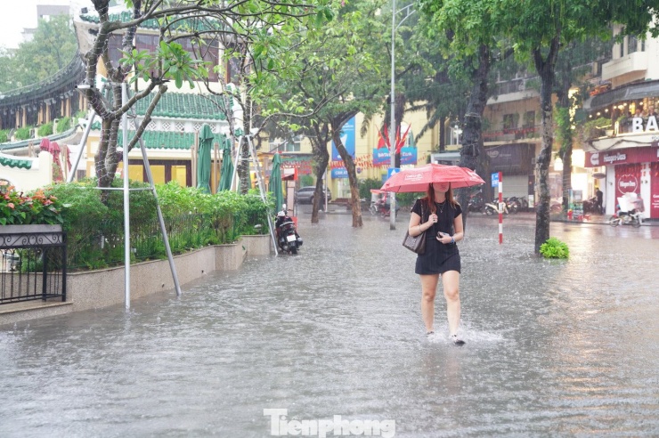 Du khách nước ngoài đi bộ gần nhà hàng Thủy Tạ