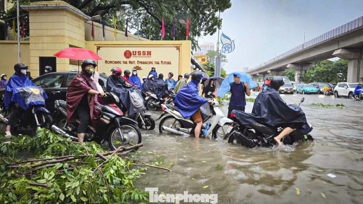 Nước ngập sâu tới nửa bánh xe, người dân qua khu vực này gặp nhiều khó khăn.