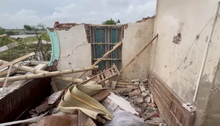 Căn nhà của bà Dâng nằm sát cánh đồng, phía sau là con kênh quanh năm khô cạn, nhưng nay nước đã lên tràn bờ. Ảnh: TT