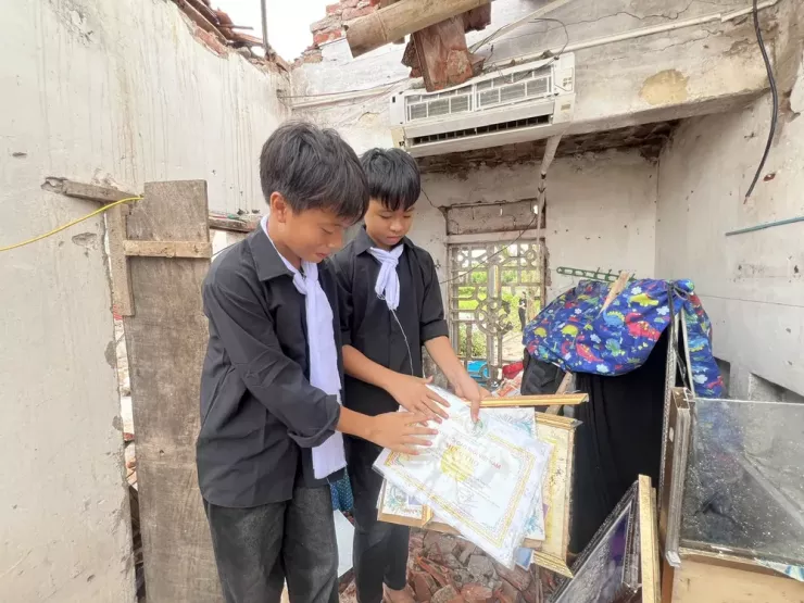 Hai cháu của bà Dâng cố gắng tìm kiếm lại những kỷ vật của bà, vừa để an ủi bản thân, cũng là cách chúng an ủi bố mẹ mình. Ảnh: TT