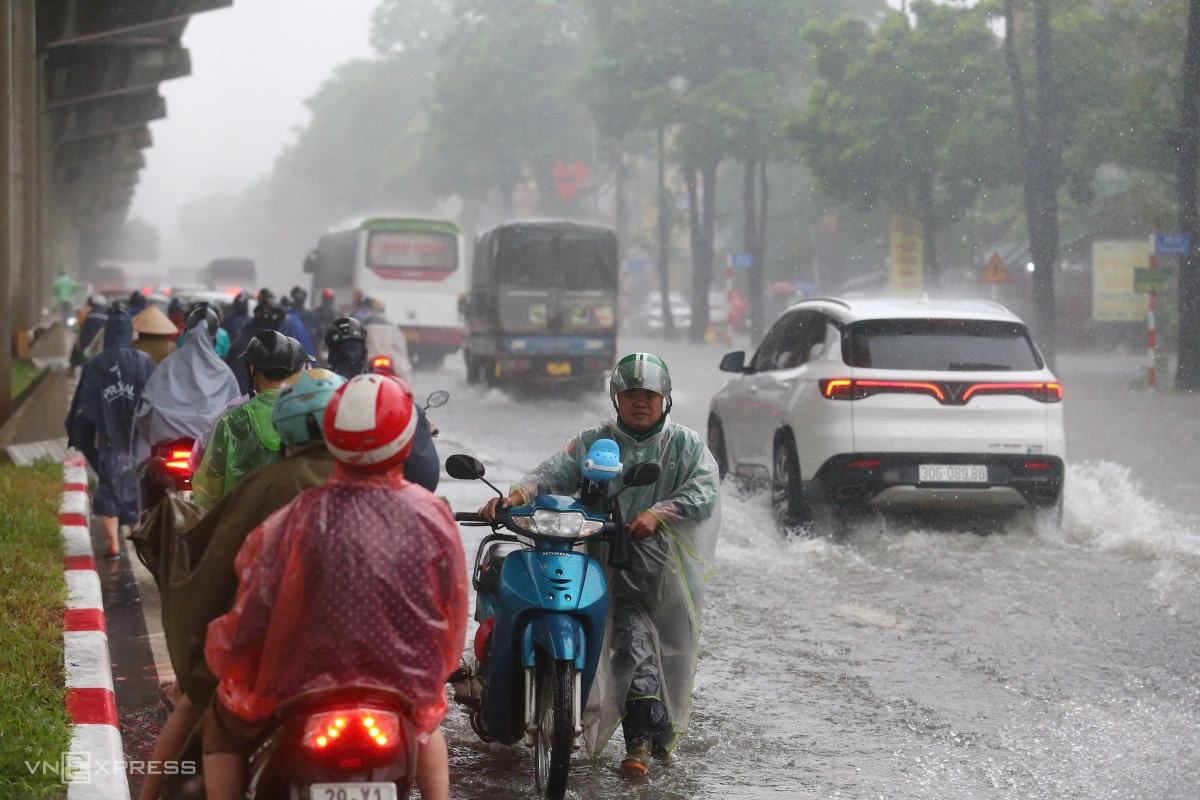 Người dân nép vào lề đường phía dưới đường sắt metro để tránh cơn mưa và tìm lối di chuyển. Ảnh:&nbsp;Phạm Chiểu