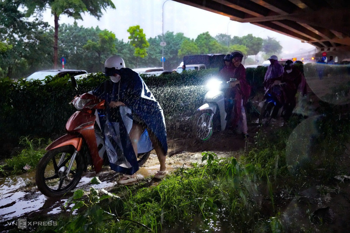 Dắt xe máy trên dải phân cách. Ảnh: Tùng Đinh