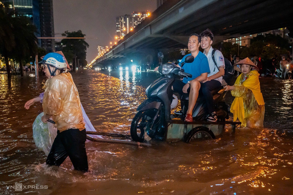 Dịch vụ chở xe máy cũng được nhiều người lựa chọn, thay vì đẩy xe hỏng trong nước ngập để về nhà. Ảnh: Tùng Đinh