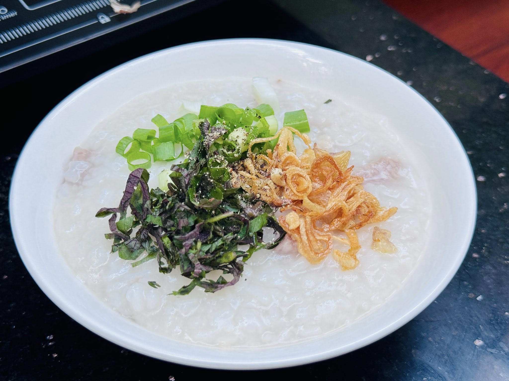 Cháo chín múc ra bát, thêm rau thơm và hành phi là có thể thưởng thức!