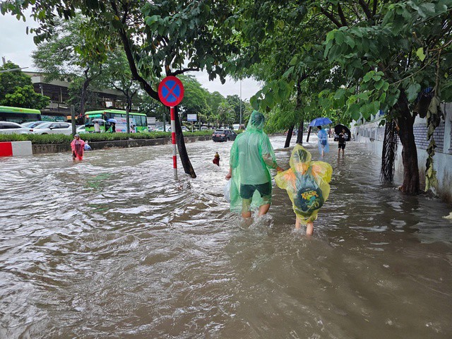 Học sinh lội nước đi học về chiều 30/9. Ảnh: Tuấn Anh