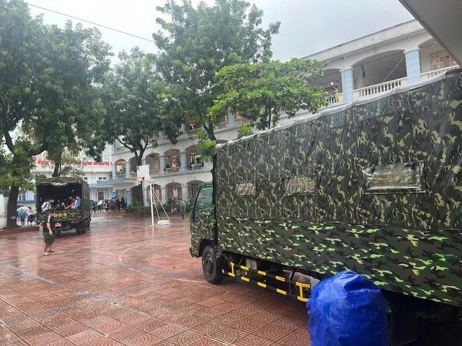 Học sinh THCS Cổ Nhuế 2 được chở bằng xe quân đội đến điểm trả đón ngoài nhà trường để tránh ngập lụt