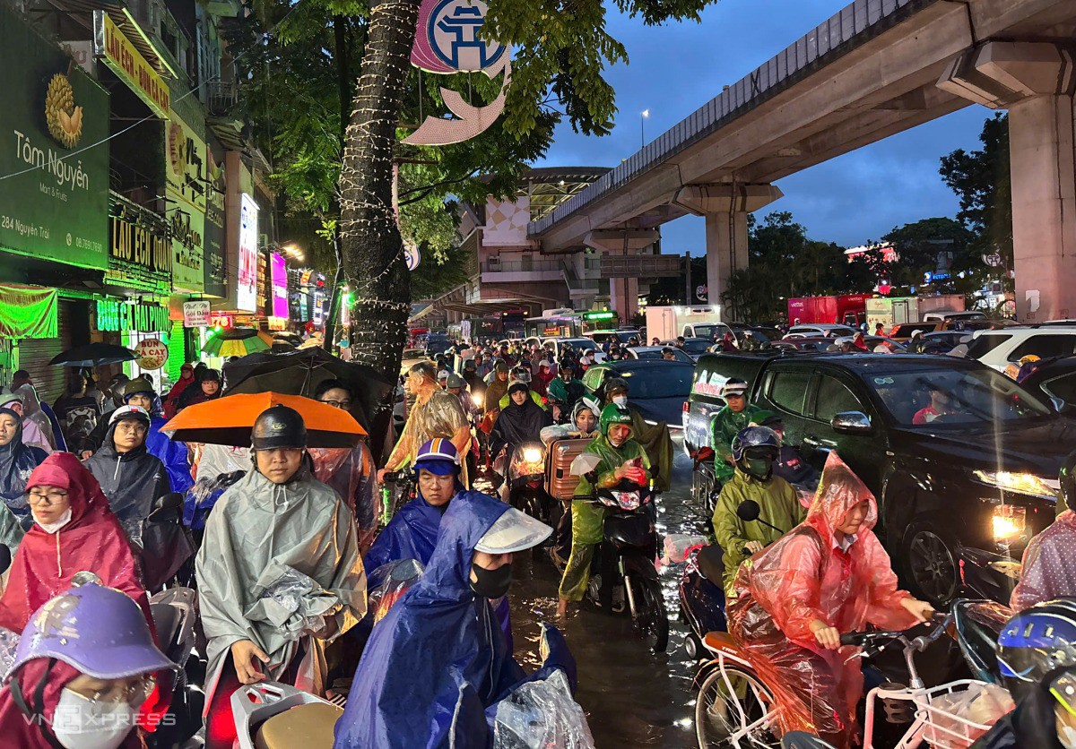 Dưới lòng đường vừa ngập vừa tắc, nhiều xe máy lao lên vỉa hè khiến giao thông thêm hỗn loạn. Ảnh: Hoàng Giang