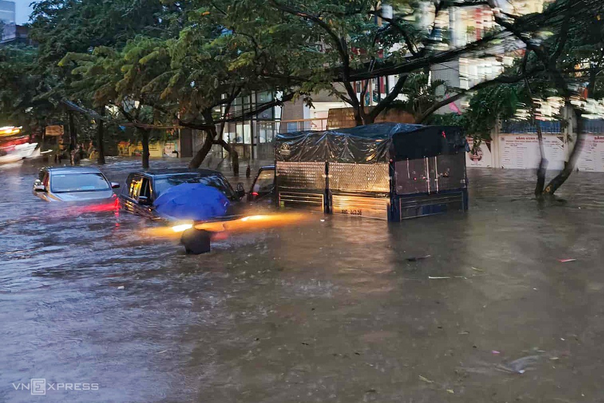 Người dân bất lực nhìn ôtô nổi lềnh bềnh trong nước ở khu vực Liễu Giai, Phan Kế Bính. Ảnh: Văn Doanh