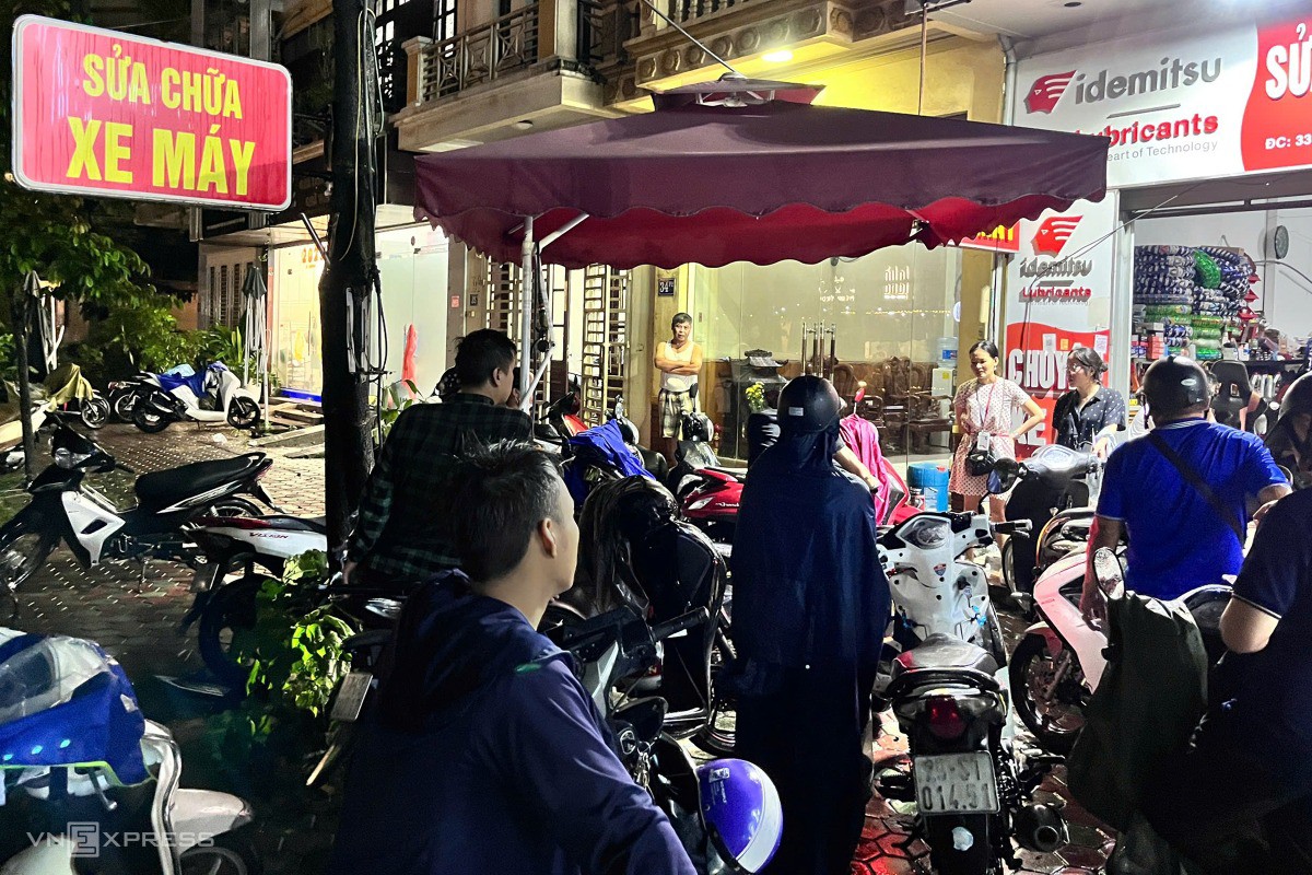 Nhiều người nóng lòng chờ đến lượt sửa xe, nhưng do lượng xe hỏng do ngập nước quá nhiều nên chưa đến lượt. Ảnh: Huy Mạnh