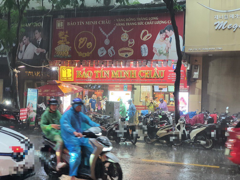 Nhiều người đội mưa đi mua vàng.