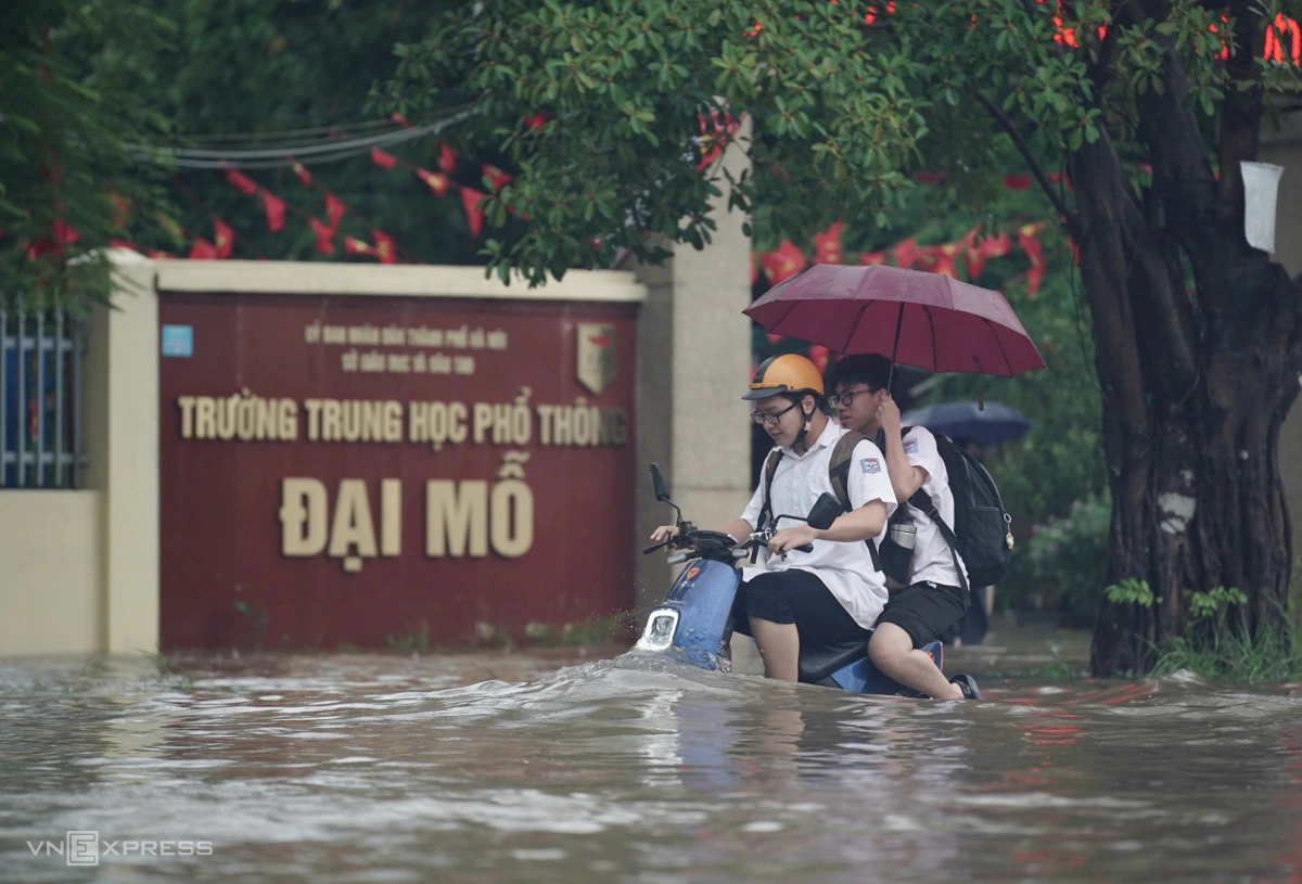 Học sinh tan trường trong cơn mưa lớn. Ảnh:&nbsp;Hoàng Giang