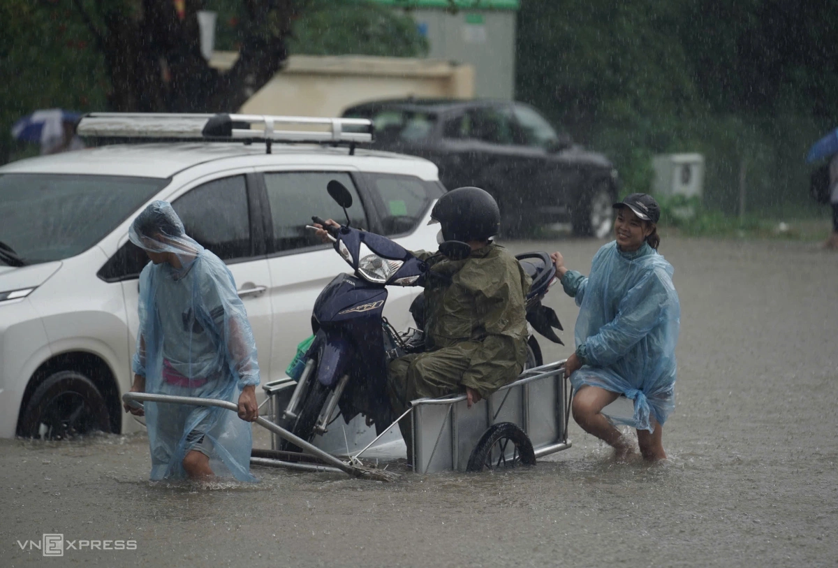 Tại một số điểm ngập sâu, nhiều người dân thuê xe kéo phương tiện đi qua với giá 50.000 đồng mỗi chuyến.