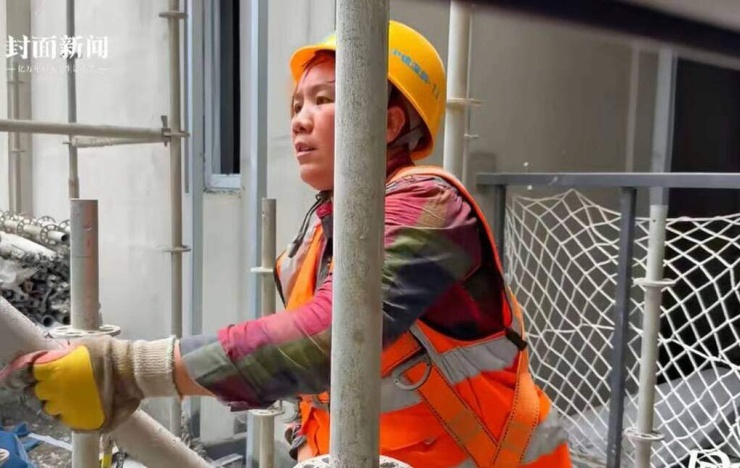 Zou Pinzhi làm công việc bê ống thép ở công trình 10 năm qua để nuôi hai con ăn học. Ảnh: Cover News