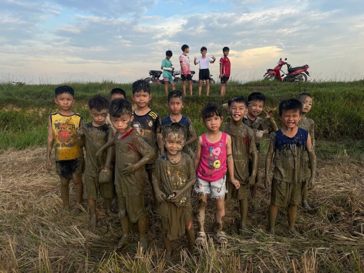 Sau mỗi giờ học, anh Tuấn tổ chức cho nhóm trẻ trong thôn Đại Tăng, xã Cẩm Duệ, Hà Tĩnh lội bùn, thay vì sử dụng điện thoại, đầu tháng 6/2026. Ảnh: Nhân vật cung cấp