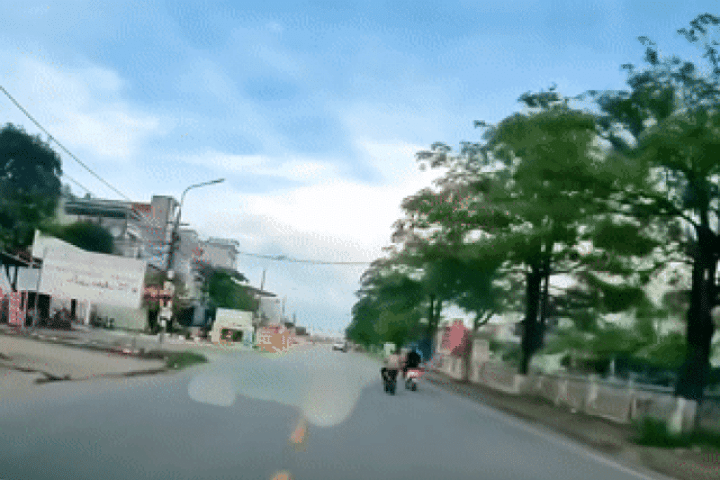 Người phụ nữ đi xe đạp điện tạt đầu xe khác, em bé ngồi sau ngã ngửa ra đường