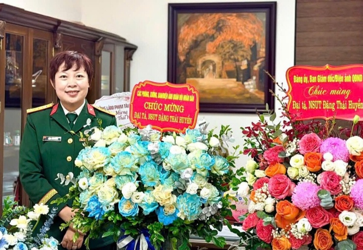 Đại tá Đặng Thái Huyền bên các lẵng hoa chúc mừng. Ảnh: FBNV 