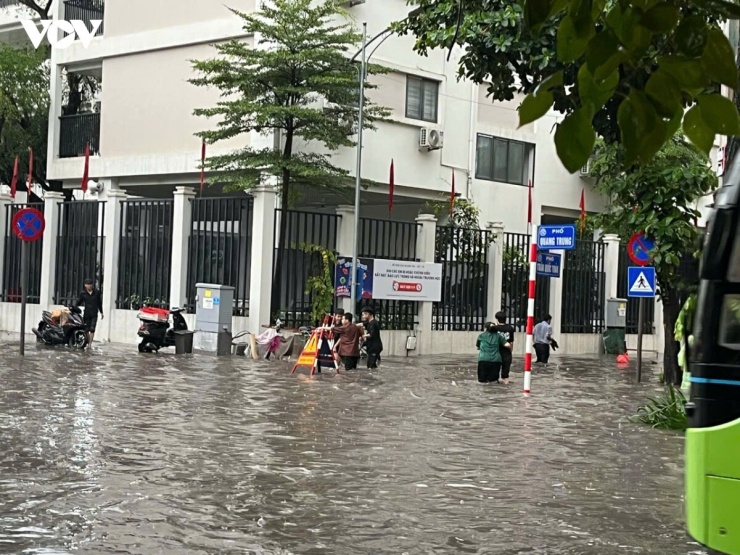 Người đi bộ, các phương tiện bì bõm trong biển nước qua phố Quang Trung - Trần Quốc Toản.