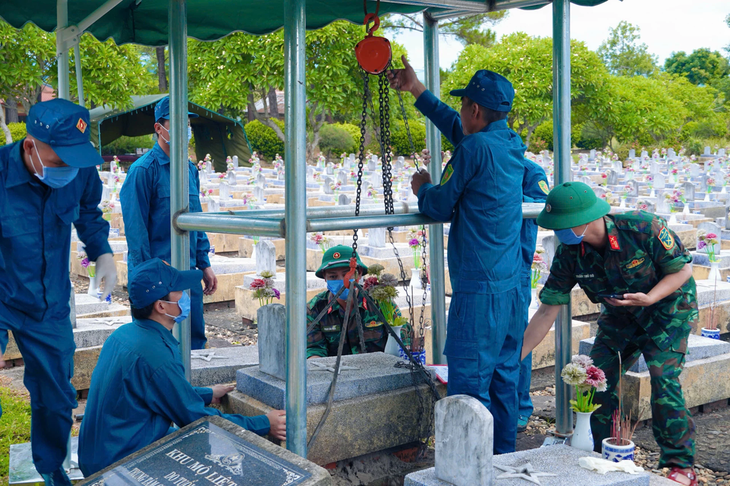 Lực lượng chức năng tiến hành công tác lấy mẫu tại các phần mộ liệt sĩ chưa xá định thông tin. Ảnh: M.H