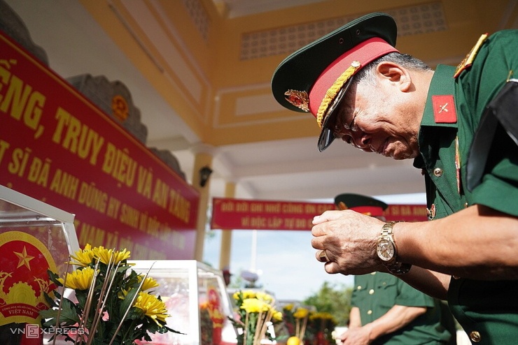 Thượng tá Lê Huy Từ bật khóc khi thắp nén hương trước hài cốt đồng đội. Ảnh: Nguyễn Đông