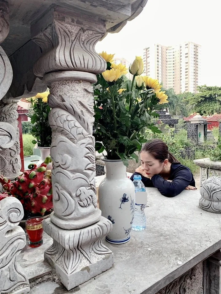 Lệ Quyên quỳ trước mộ bố. Ảnh: NVCC