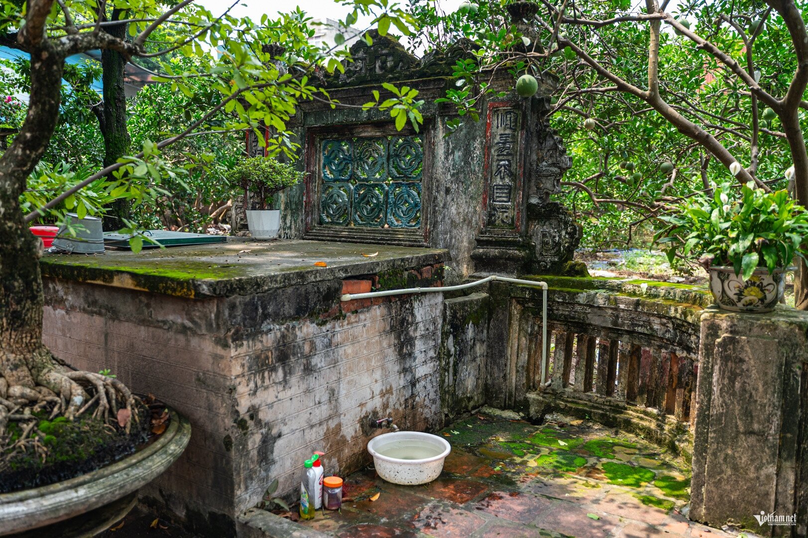 Trong sân nhà vẫn còn tấm bình phong, bể nước chạm trổ hoa văn gần trăm năm, được giữ gìn nguyên vẹn. Ảnh: Huy Nguyễn