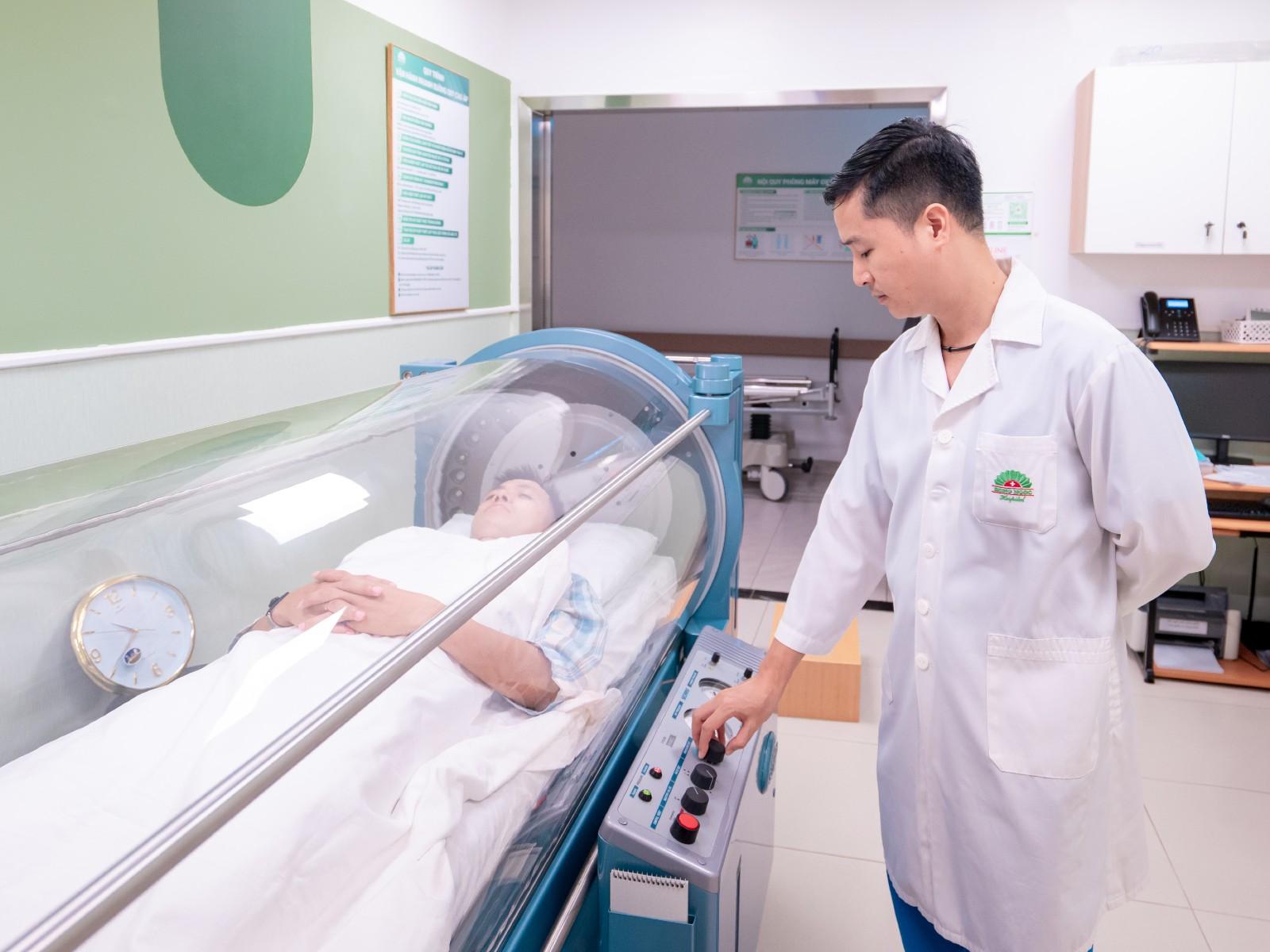 Cầu thủ Văn Quyết sử dụng oxy cao áp dưới sự vận hành của bác sĩ Hào - Ảnh: BVĐK Hồng Ngọc