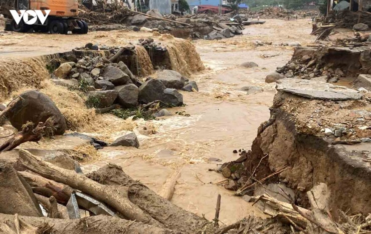 Nền đường quốc lộ 32 dài gần 1km đã bị nước lũ cày sới tạo thành dòng suối.