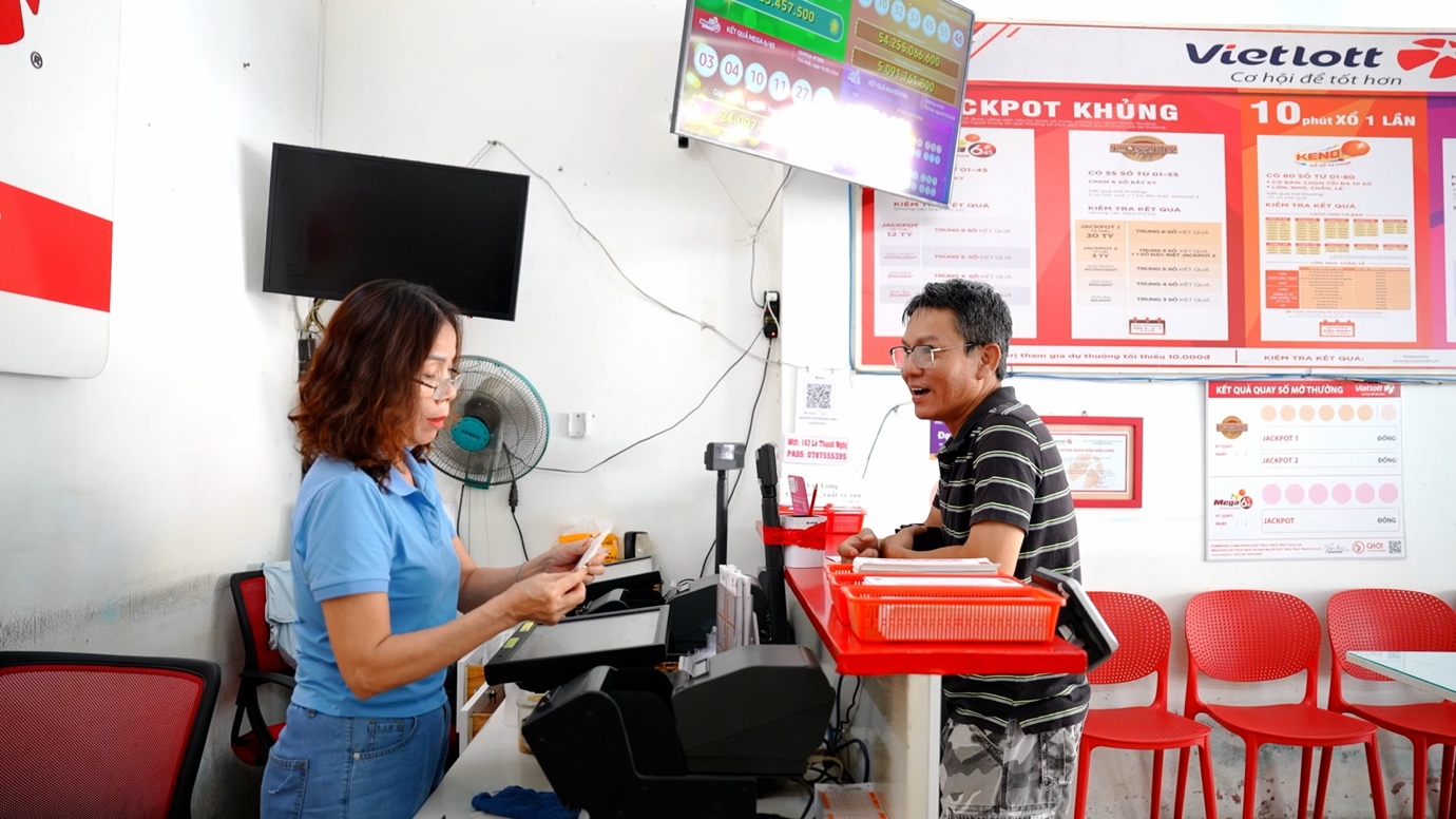 Ở tuổi gần 60, bà Phương Anh vẫn đều đặn tư vấn và phục vụ khách hàng tại điểm bán Vietlott mỗi ngày