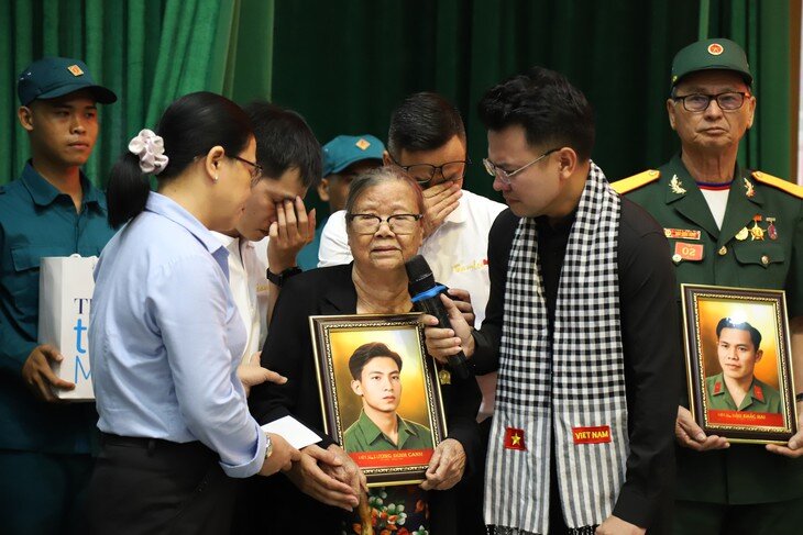 Niềm vui xen lẫn những giọt nước mắt trong giây phút thân nhân nhận lại di ảnh người đã hy sinh. Ảnh: P.Thương.