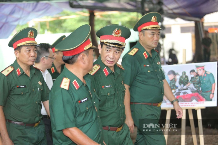 Đại tướng Phan Văn Giang nghe báo cáo tiến độ công tác tìm kiếm, quy tập hài cốt liệt sĩ tại công viên Lê Thị Riêng. Ảnh: Lê Giang